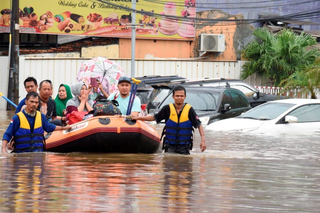 A rescue team evacuates locals on an inflatable boat during a flood after heavy rain in Bekasi, near Jakarta