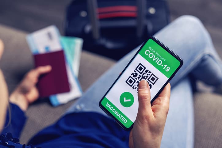 vaccinated person using digital health passport app in mobile phone for travel during covid-19 pandemic