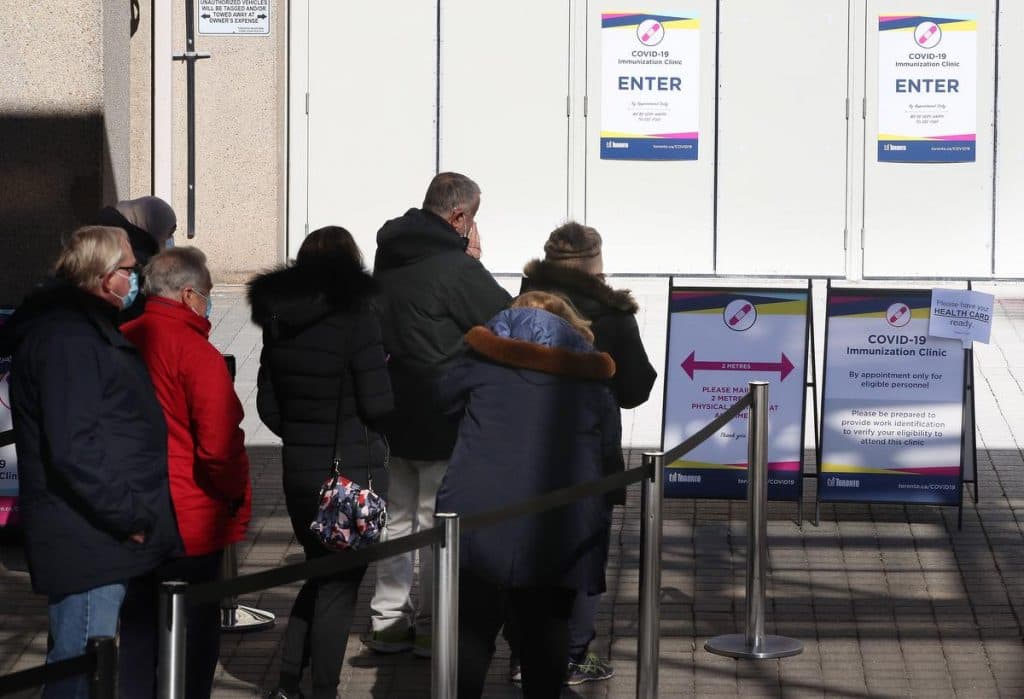 People line up at the COVID-19 vaccination clinic at the Metro Toronto Convention Centre. Ontario tightens restrictions to slow the spread of the COVID-19 pandemic