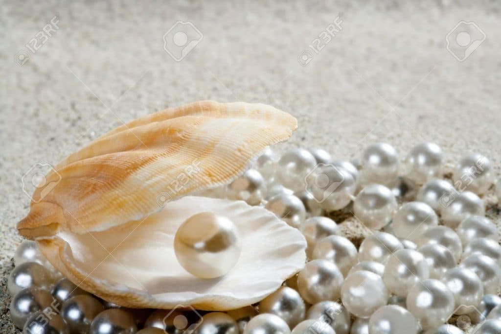 10437690-caribbean-pearl-inside-clam-shell-over-white-sand-beach
