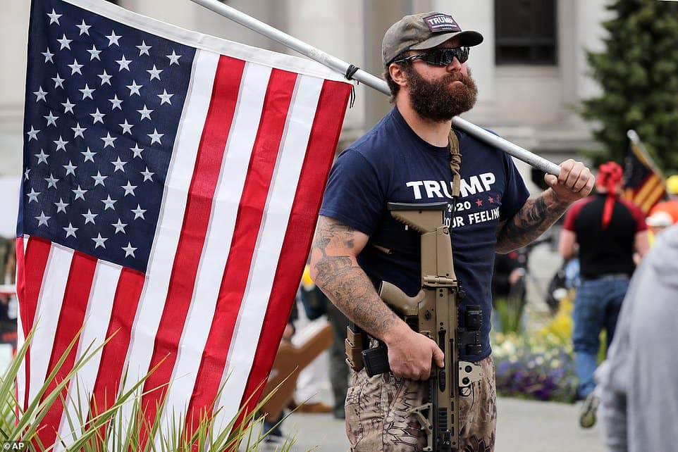 27398112-8235127-Justin_Bailey_of_Tacoma_Wash_holds_an_assault_rifle_and_a_flag_a-a-6_1587351541491